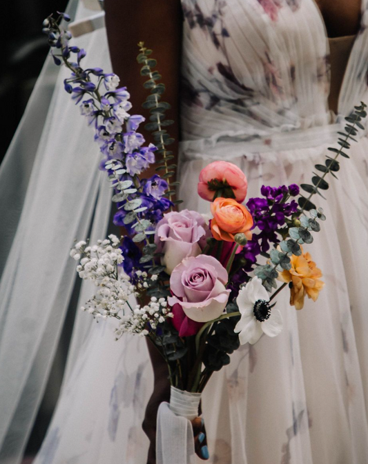 Bouquet of flowers held by a person in a wedding dress.